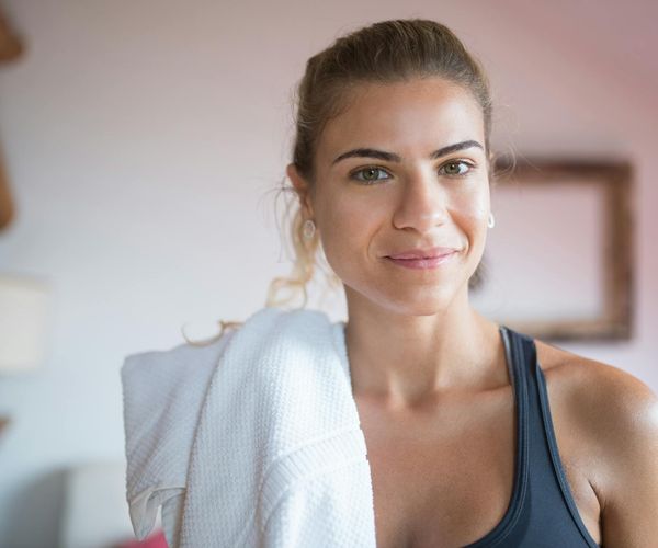 A person smiling peacefully, feeling revitalized after a gentle workout session.